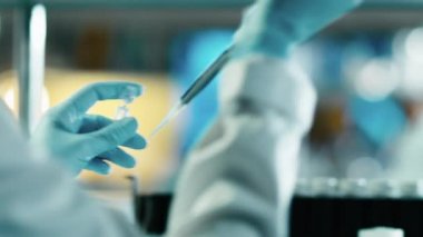 Bir bilim adamı bir laboratuvarda bir mikro pipet kullanarak yakın çekim görüntüleri.