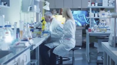 Takım beyaz kat olarak beyaz bilim adamları modern bir laboratuvarda çalışan.