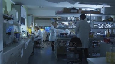 Beyaz beyaz kat grup modern bir laboratuvarda çalışan.