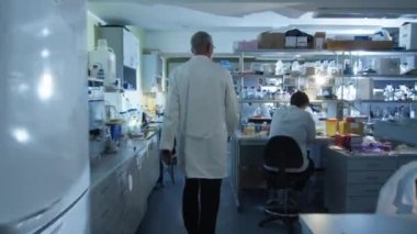 Beyaz önlük içinde üst düzey bilim adamı tebrik meslektaşları bir laboratuvar olduğunu.