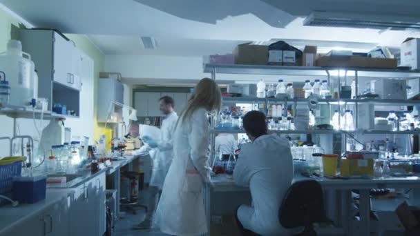 Groupe de scientifiques caucasiens en blouse blanche travaillent dans un laboratoire moderne . — Video