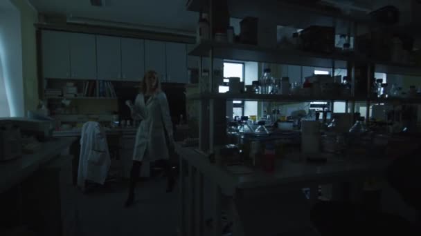 A cientista loira vem ao laboratório e acende as luzes. . — Vídeo de Stock