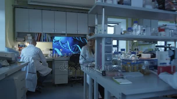 Grupa kaukaski naukowców w białych płaszczach pracują w nowoczesnym laboratorium. — Wideo stockowe