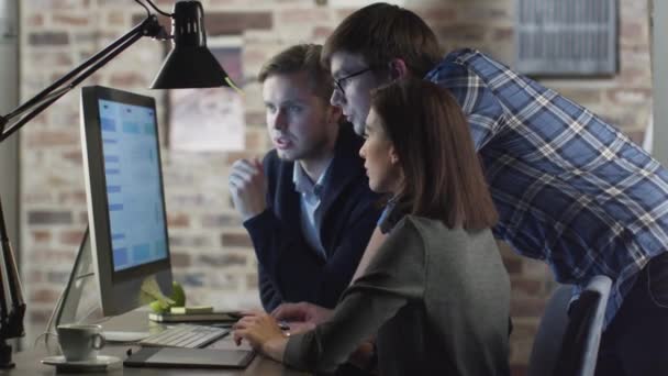 Equipe de jovens designers estão discutindo um projeto de trabalho em uma tela de computador . — Vídeo de Stock