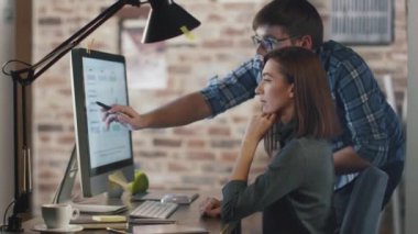 Genç bir adam ve kadın bir çatı katında bir bilgisayar üzerinde çalışırken bir projeyi tartışıyorlar..