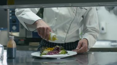 Ticari mutfak mutlu profesyonel şef süsleme ve salata hizmet.