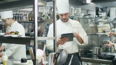 Ticari mutfak bir restoran ya da otel profesyonel şef bir tablet bilgisayar kullanıyor.