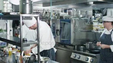 Bir restoran ya da otel yiyecek hazırlama ticari bir mutfakta üç profesyonel şefler Timelapse görüntüleri.
