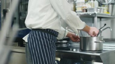 Bir restoran ya da otel ticari mutfak mutlu profesyonel şef çorba tatma.