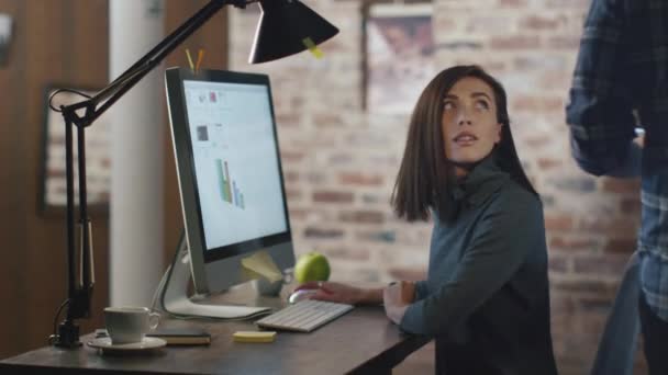 Fiatal férfi és nő működő-ra egy számítógép, és miközben megbeszélnek egy projektet tabletta. — Stock videók