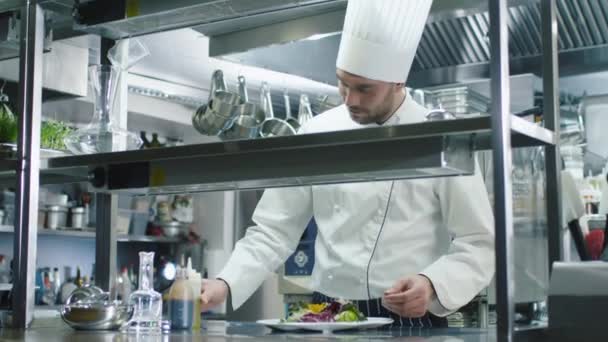 Chef profissional feliz em uma cozinha comercial é enfeitar e servir salada . — Vídeo de Stock