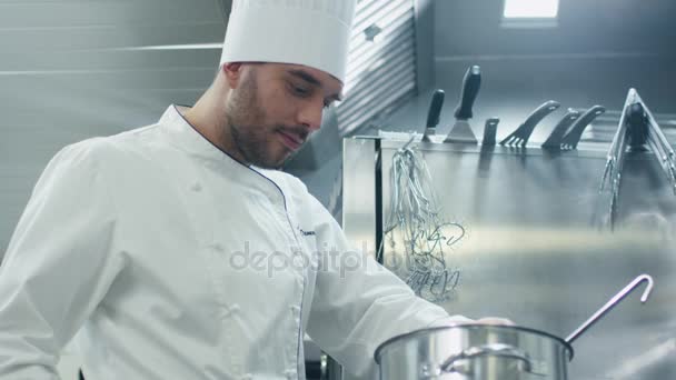 Glücklicher professioneller Koch in einer gewerblichen Küche in einem Restaurant oder Hotel probiert Suppe. — Stockvideo