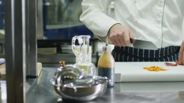 Chef profissional em uma cozinha comercial em um restaurante ou hotel está cortando legumes verdes . — Vídeo de Stock