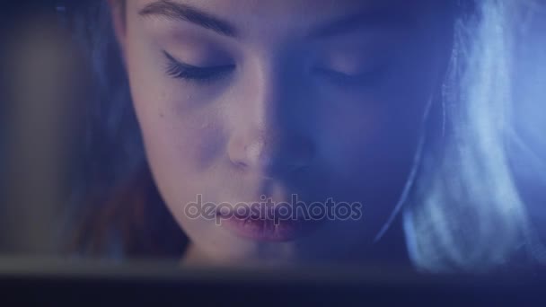 어둠 속에서 작업 태블릿을 찾고 아름 다운 젊은 여자의 초상화 샷. — 비디오