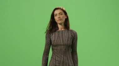 Esmer kadın elbiseli bir mock-up üzerinde yürüme arka planda yeşil ekran.