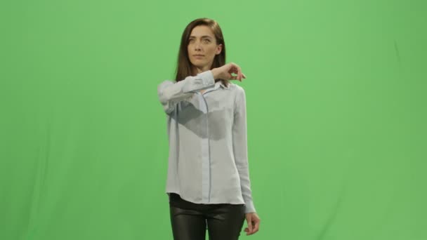 Mulher está trabalhando com uma interface interativa virtual em uma tela verde mock-up em segundo plano . — Vídeo de Stock