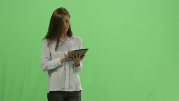 Woman is using a tablet computer on a mock-up green screen in the background. — Stock Video