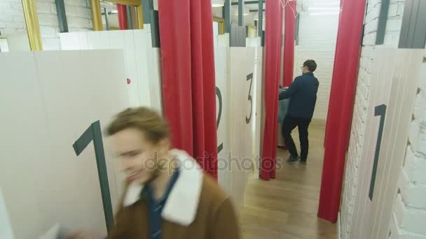 Imágenes rápidas del timelapse de personas entrando y saliendo de probadores en una tienda departamental . — Vídeo de stock