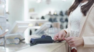 Yakın çekim shot bir mağaza nakit masasında bir kart ile ödeme genç bir kadın.