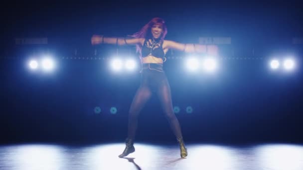 Dançarina caucasiana com cabelo roxo está dançando em um palco escuro fumegante . — Vídeo de Stock