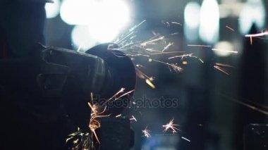 İşçi açı değirmeni ile metal işleme sanayi ortamında yapar. Kıvılcım yansımalar