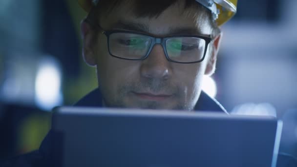 Technician in Glasses and Hard Hat Using Tablet in Industrial Environment. Reflections of Screen Glasses — Stock Video