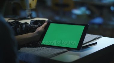 Terzi bir tablet ile bir mock-up perde içinde kır manzarası tarz tutuyor.