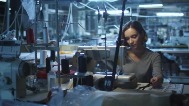 Jeune femme travailleuse du vêtement coud dans une usine de vêtements pendant un quart de nuit .