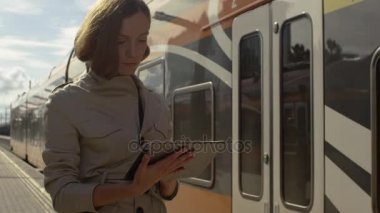 Tablet tren istasyonu kullanan kadın