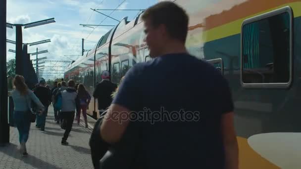 Grupa dzieci z są biegnące w kierunku odejścia pociągu w Tallinie stacja kolejowa. — Wideo stockowe