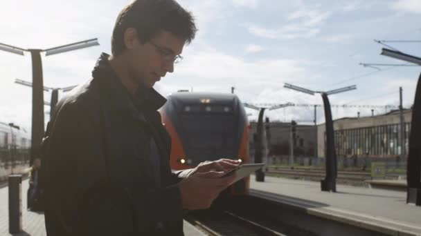 Ο άνθρωπος που χρησιμοποιούν Tablet Pc σε σιδηροδρομικό σταθμό — Αρχείο Βίντεο