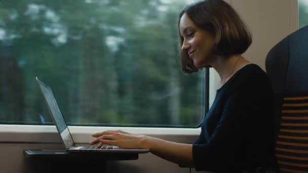 Donna che lavora al computer portatile la mattina presto in treno in movimento . — Video Stock