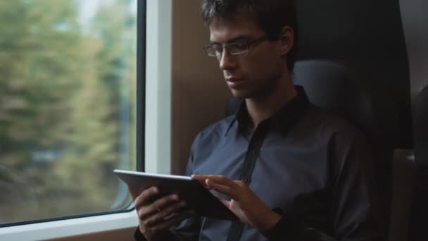 Людина використовує планшетний ПК під час подорожі поїздом — стокове відео