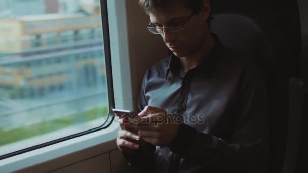 Man met behulp van de telefoon tijdens het reizen op de trein — Stockvideo