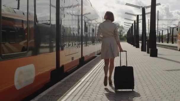 Уверенная женщина с багажом ходьба по вокзалу — стоковое видео