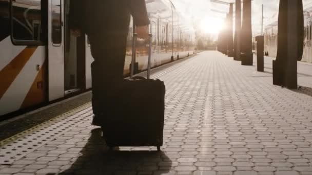 Självsäkra mannen med bagage går på järnvägsstationen vid solnedgång — Stockvideo