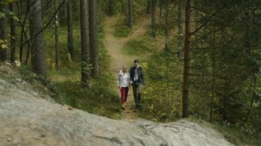 Çift yürüyüş ve bir sonbahar orman izi yokuş yukarı gidiyor. 