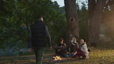 Burada arkadaşları kamp ateşi yanında oturan ve bir kızla ona sarıl ile tanışır campside için adam geldi.