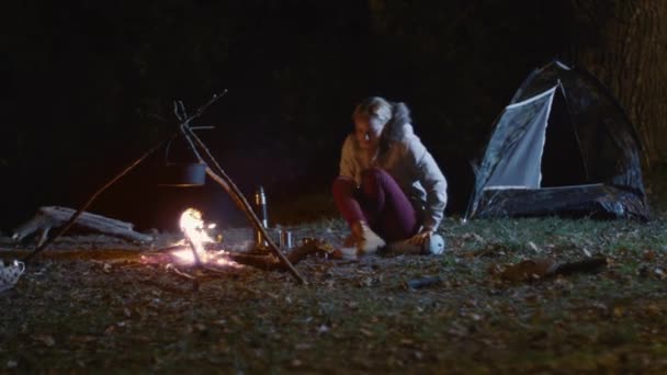 Meisje uit een brandende kampvuur opgestaan en ging naar tent's nachts. — Stockvideo