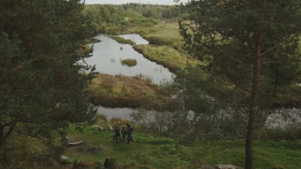 Dva páry hledají na lesní krajina s jezerem z kopce. — Stock video