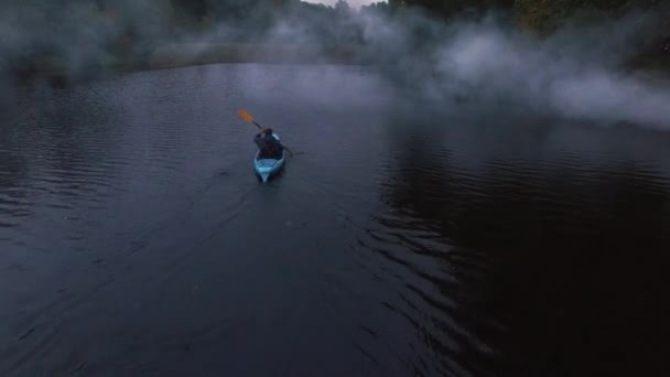 Aerial drone strzał człowieka w niebieski kajak w rzece w lesie. — Wideo stockowe