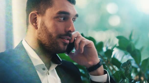 Retrato de un hombre de negocios en traje hablando por teléfono y sonriendo . — Vídeo de stock