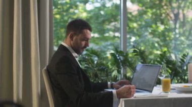 İşadamı kredi kartını bir restoranda bir dizüstü bilgisayarda online alışveriş için ödeme için kullanır.