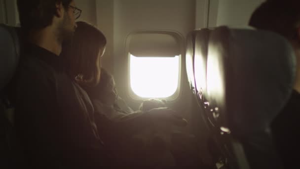 Junge Familie mit einem Jungen sitzt im Flugzeug neben einem Fenster. — Stockvideo