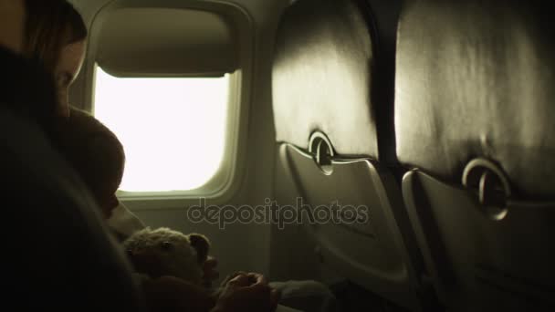 Familia joven con un niño sentado dentro de un avión al lado de una ventana . — Vídeos de Stock