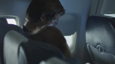 Genç adam gemide tablet bir kadın oturup onun yanında ise bir uçak kullanma.