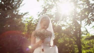 Mutlu genç gelin gelinlik güneşli bir ormanda, çalışıyor.