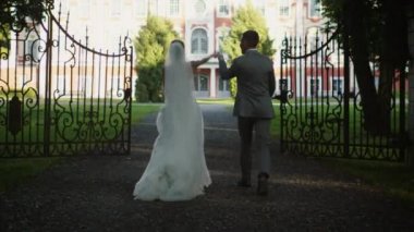 Gelin ve damat bir parkta bir konak doğru hareket.