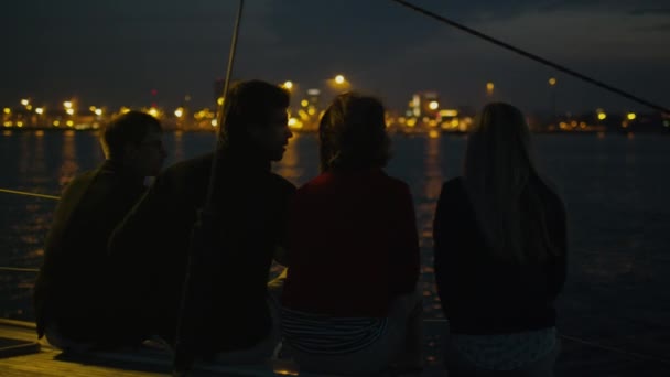 Grupo de personas relajándose en un yate en el mar por la noche . — Vídeo de stock