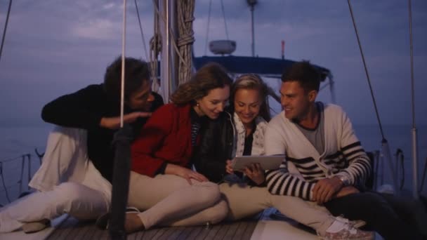 Group of people are using tablet on a yacht in the sea at night. — Stock Video